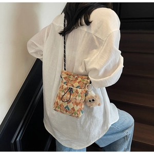 Détail du sac bandoulière bohème tissé coloré avec un pendentif peluche monstre unique