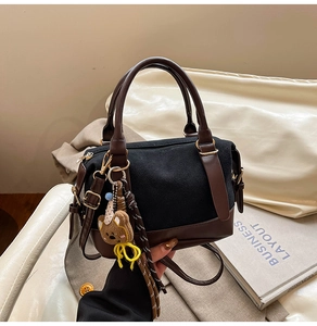 Detail of vintage Boston bag with brown leather trim and cute bear charm pendant