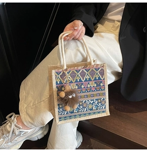 Detail of colorful ethnic pattern woven mini tote bag with cute monster plush charm