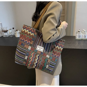 Detail of colorful geometric canvas tote bag with woven strap and branding patch