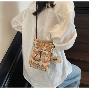 Détail du sac à bandoulière à motifs géométriques avec pendentif en peluche