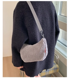 Détail de la texture du sac bandoulière en peluche grise et sa sangle en tissu