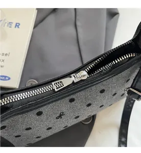 Close-up of smooth silver metal zipper and polka dot fabric on shoulder bag