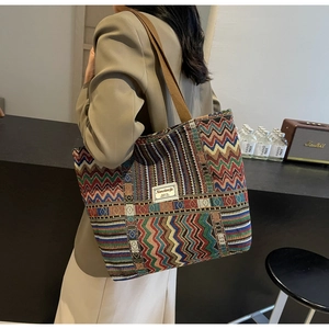 Detail of colorful woven tote bag featuring ethnic wave patterns and branded fabric label