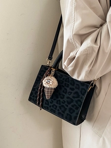Fashionable leopard print tote bag for women with gold hardware and plush charm accessory
