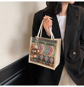 Ethnic woven tote bag in beige linen with geometric patterns and monster charm accessory