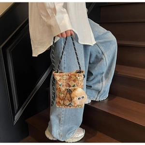 Détail du sac seau en toile géométrique avec motifs colorés et breloque en peluche