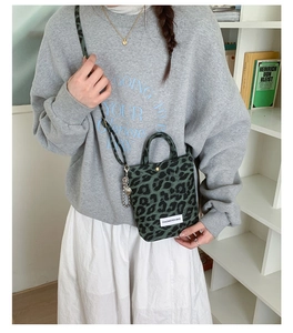 Detail of trendy green leopard canvas mini bag with adjustable strap and metal ornament