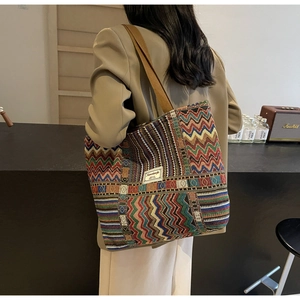 Detailed view of the large capacity woven canvas bucket bag on model's shoulder