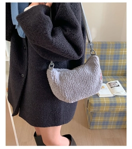 Détail de la texture d'un sac demi-lune gris en peluche avec bandoulière et étiquette
