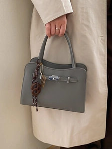 Fashionable grey textured leather square shoulder bag with silver turn-lock and woven pendant