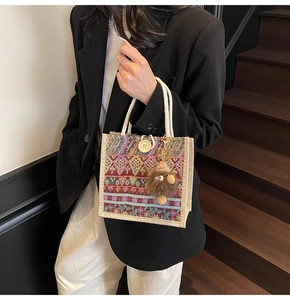Ethnic woven tote bag with colorful geometric patterns, wooden button and fuzzy charm
