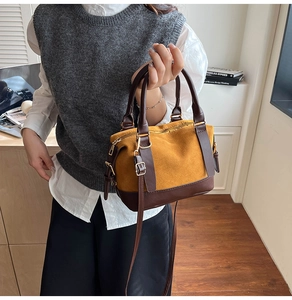 Detail of yellow matte and brown leather patchwork boston bag with gold hardware