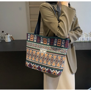 Detail of colorful geometric pattern canvas tote bag with woven shoulder strap and label