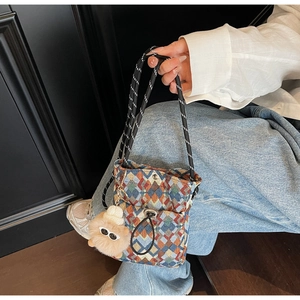Détail du sac bandoulière en tricot coloré à motif géométrique avec breloque peluche