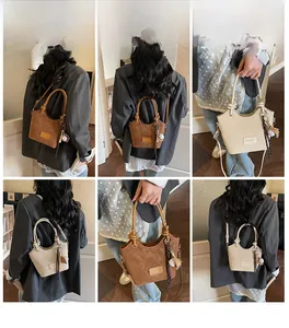 Detail view of stylish bucket bag with plush charm in brown and cream PU leather