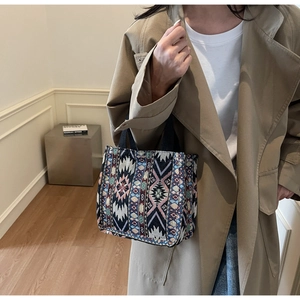 Macro view of woven bohemian tote bag featuring intricate jacquard texture and strap
