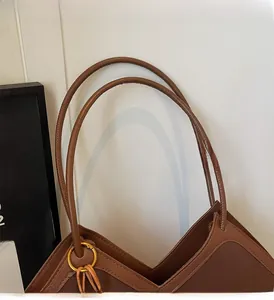 Close-up of the durable brown leather handle and sturdy gold metal ring connectors