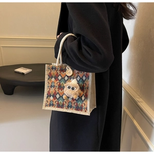 Detail of quilted linen handbag featuring a wooden button closure and cotton rope handles