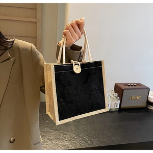 Detail of black rose jacquard tote bag with jute handles and decorative wood button