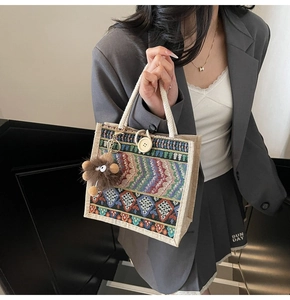 Close-up of woven lunch bag with geometric patterns and monster pendant accessory