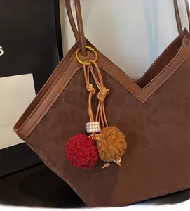 Close-up of large leopard tote bag with V-shaped opening and plush bag charm detail