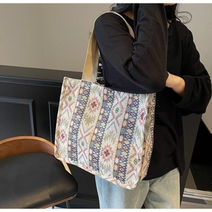 Detailed view of canvas tote bag featuring ethnic geometric patterns and sturdy handles