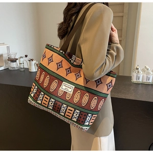 Detailed shot of ethnic woven tote bag with colorful geometric patterns and shoulder strap