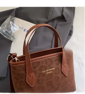 Detailed view of brown tote bag with leopard print texture on smooth leather surface