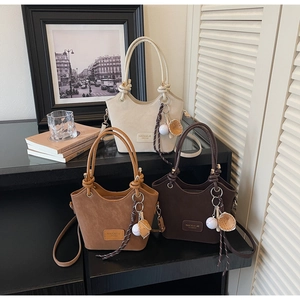 Three leather bucket bags in beige, light brown, and dark coffee with baseball charms