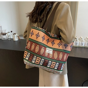 Detail of bohemian knit tote bag with colorful geometric patterns and fabric strap