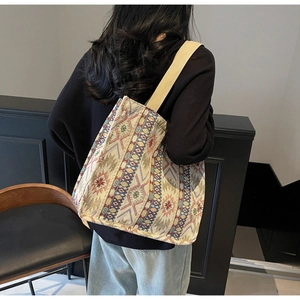Detailed back view of a woman wearing a large ethnic tote bag with woven geometric patterns