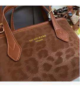 Detail of brown leopard embossed texture and golden logo on the autumn tote bag