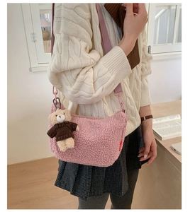 Détail du sac bandoulière en peluche rose avec breloque ours et sangle large