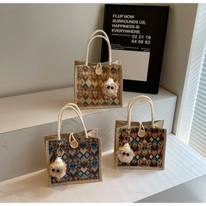 Detailed view of geometric pattern linen handbags with soft rope handles and plush charms