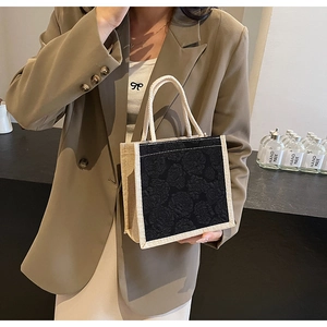 Detail of elegant hand-held tote featuring black rose jacquard and khaki woven fabric