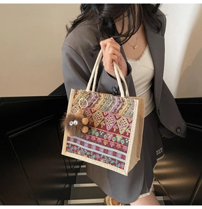 Close-up of bohemian woven tote bag with colorful geometric patterns and plush charm