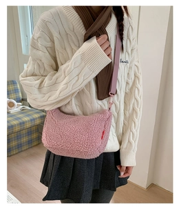 Vue détaillée du sac à bandoulière rose en peluche et de la sangle en tissu porté par le modèle