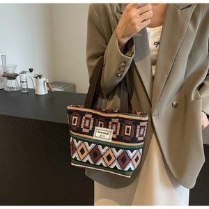 Close-up of geometric woven bucket bag with retro pattern and brand label detail