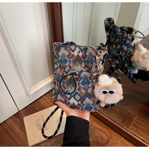 Détail du sac de téléphone en jacquard bohème avec sangle en corde et pendentif peluche