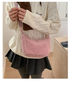 Sac bandoulière en peluche rose avec large sangle porté par un mannequin en hiver