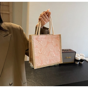 Detail of pink floral jacquard tote with woven cotton rope handles and burlap sides
