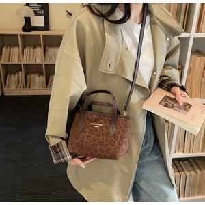 Detail of vintage leopard print tote bag with brown leather handles in aesthetic setting