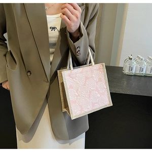 Detailed close-up of a mini linen tote bag with pink floral jacquard and cotton rope handles