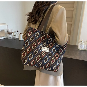Detail of large canvas bucket bag with colorful geometric jacquard pattern and shoulder strap