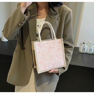 Close-up of pink rose floral jacquard pattern and woven texture on a tote bag detail