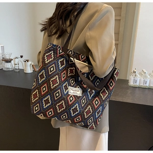 Detail of bohemian geometric canvas bucket bag featuring vintage patterns and woven handles