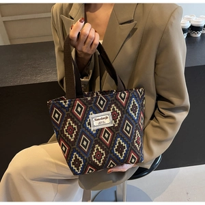 Detail showing the intricate ethnic geometric jacquard pattern on a canvas bucket bag