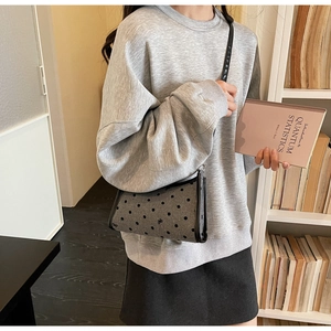Polka dot crossbody bag with grey wool fabric texture and black trim details