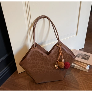 Detailed view of large leopard print tote bag with V-cut opening and plush ball charm